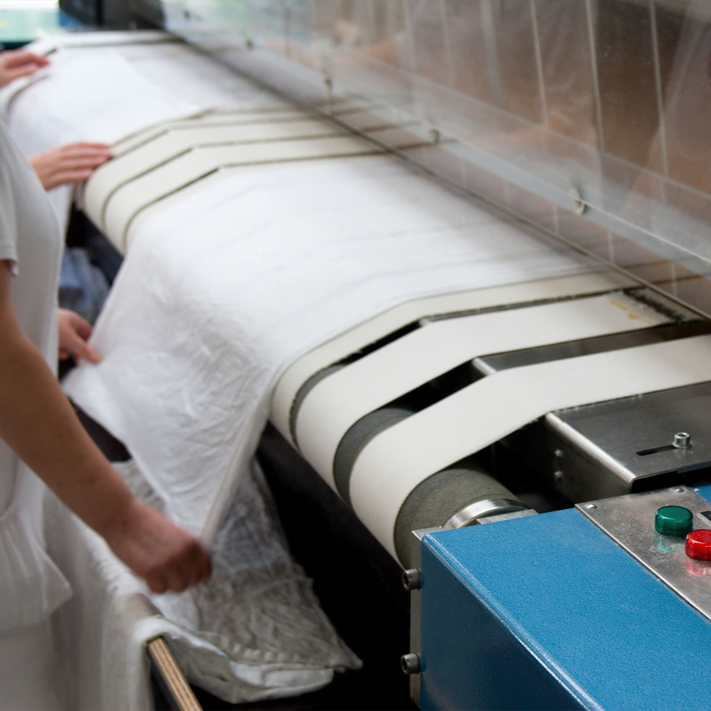 Textilien kommen aus einer industriellen Bügelmaschine